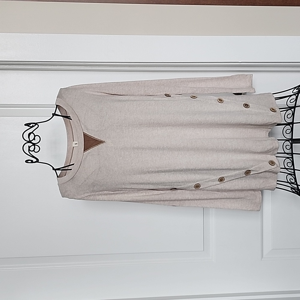 Tan long sleeved knit shirt with button detail.